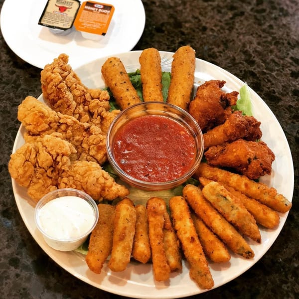 Lighthouse Diner's appetizer platter with chicken tenders, mozzarella sticks, fried zucchini, and wings with dipping sauces.